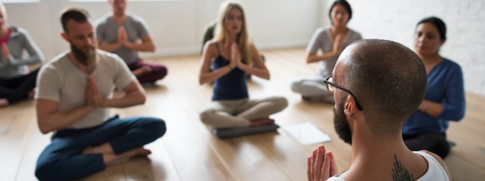 immagine rappresenta un mental coach che fa meditazione guidata ad un gruppo di studenti